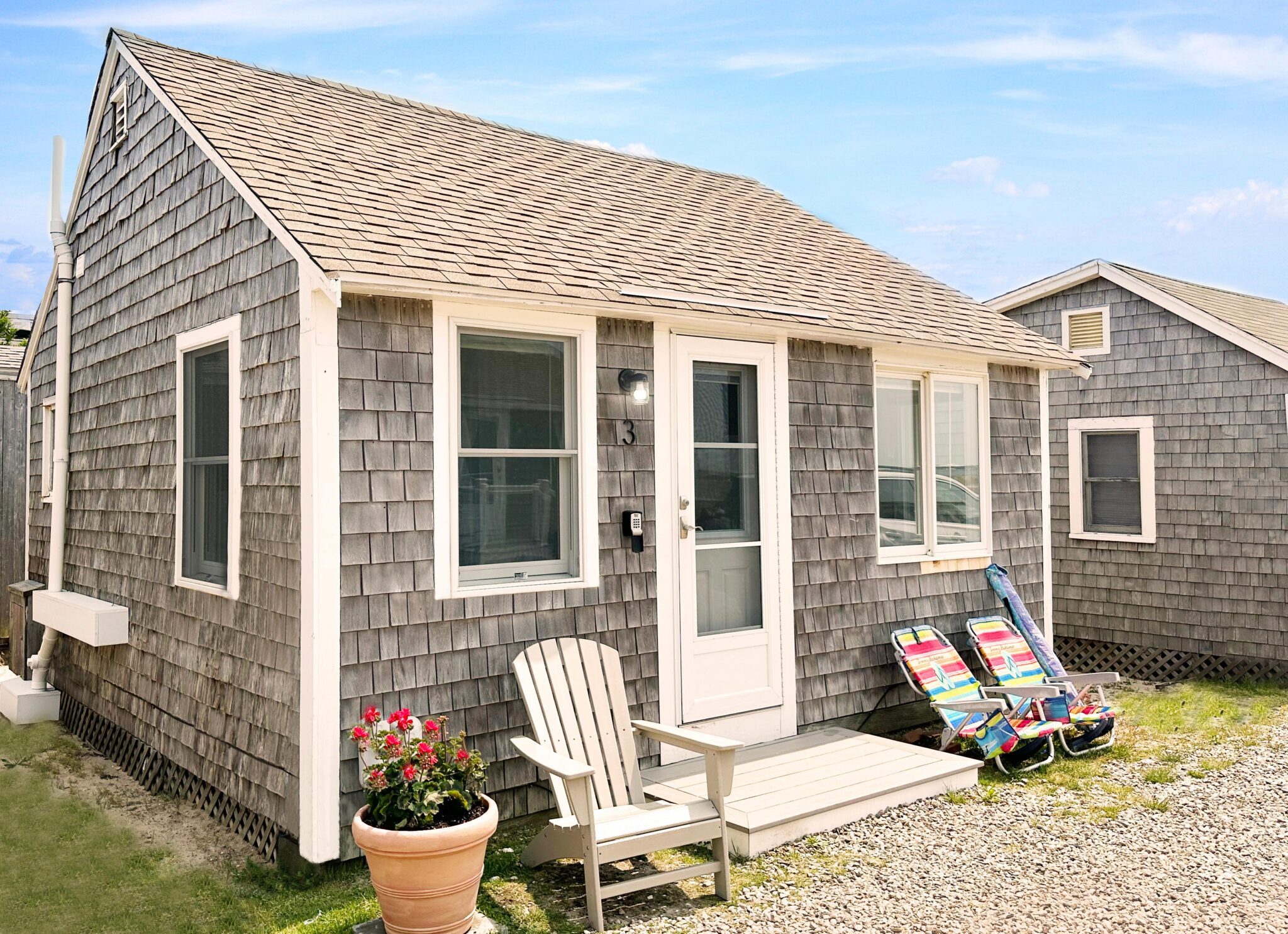 A shingled beach cottage with white trim.