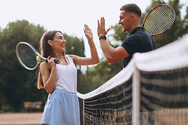 Young couple completing game of tennis